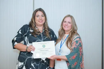 Tracy, left, receives a certificate for the fact sheet from a woman