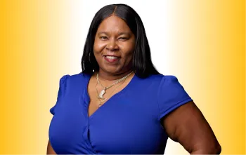 Headshot of Janine Woods wearing a blue dress