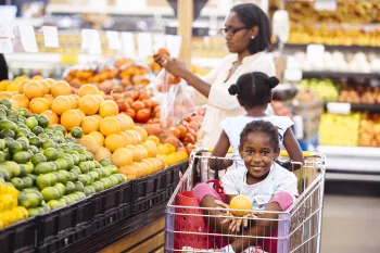 Family shopping for fresh fruits and vegetables in a market