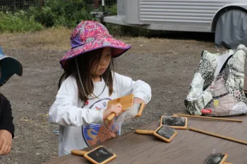 A little girl brushes wool