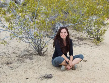 Marisela Chávez sits on sand at a beach