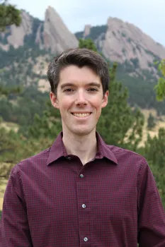 Headshot of Daniel with mountains in background