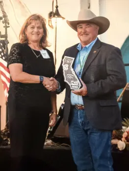 Sheila on left receives a plaque shaped like the state of California