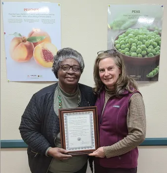 Mary Blackburn holds a framed certificate with Annette Laverty