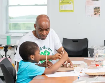 4-H adult helping a youth with an educational activity