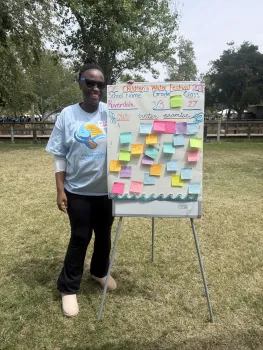 Large board filled with colorful student notes showing promises to save water and reduce pollution.