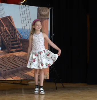 4-H member takes the stage, proudly modeling a garment she designed and created