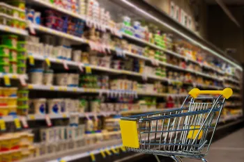 cart in front a stocked shelves in a grocery store