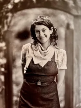Tamar Ingber, the class instructor, a sepia image on Tamar wearing coveralls and smiling.