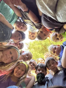 Kids in a circle looking down at a camera for an aesthetic look