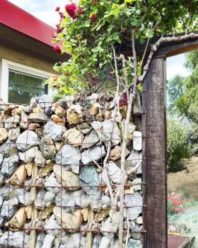 Reduced fire risk non-combustible fence of rock and wire in Zone 0