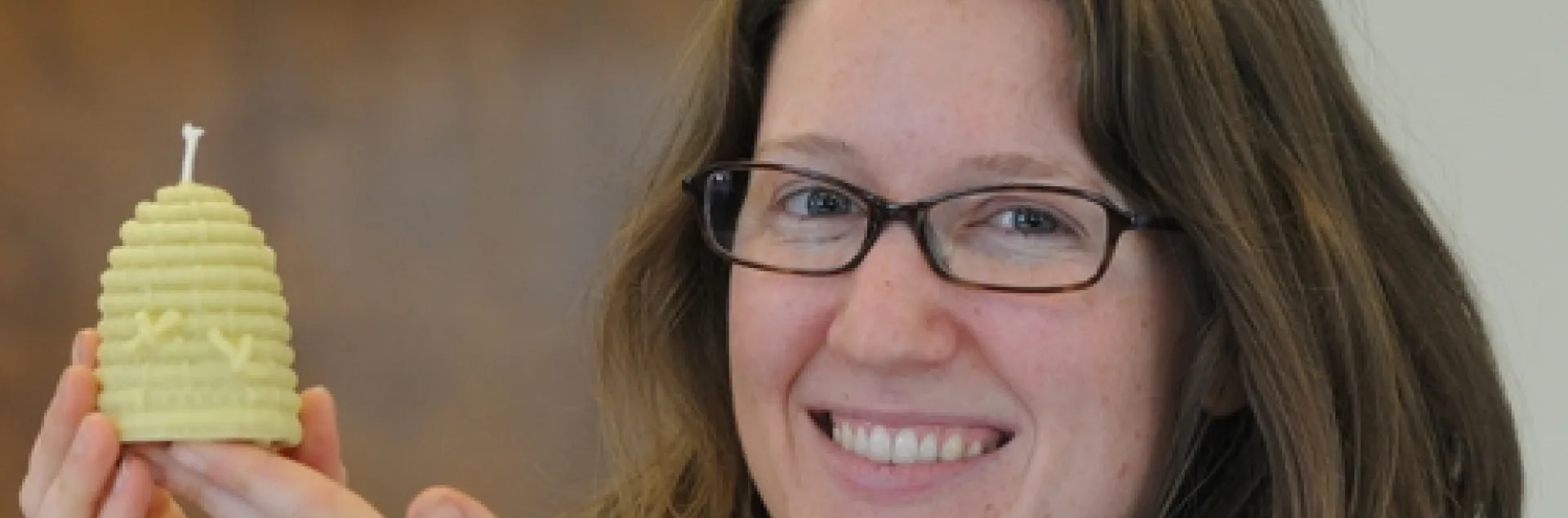 BEEKEEPER Elizabeth Frost shows a miniature beehive candle she made from beeswax and a little paraffin. (Photo by Kathy Keatley Garvey)