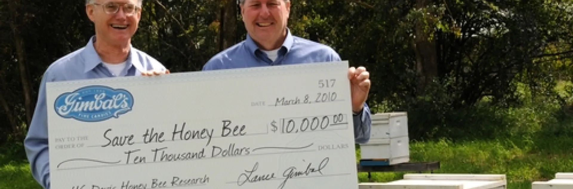 HELPING TO SAVE the honey bees is Gimbal's Fine Candies, which is donating 5 percent of the proceeds from its Honey Lovers' fruit chews to UC Davis research. Accepting the first check, issued March 8, is Extension apiculturist Eric Mussen (left) from Lance Gimbal, CEO of Gimbal's. (Photo by Kathy Keatley Garvey)