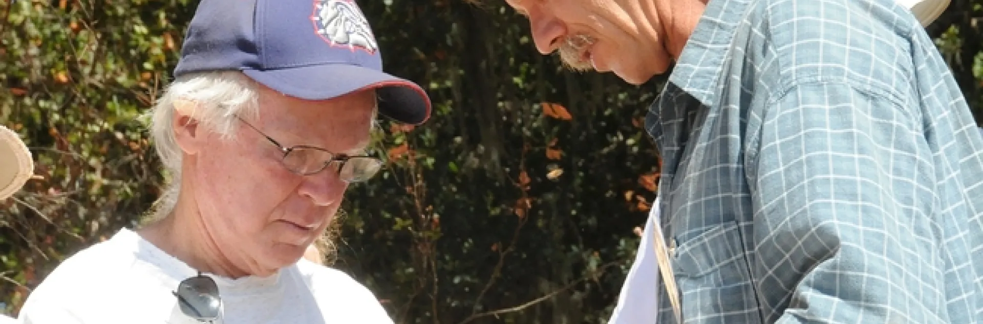 eekeepers Bill Cervenka (left) of Half Moon Bay and Randy Oliver of Grass Valley check out a frame in Healdsburg during a bee conference. (Photo by Kathy Keatley Garvey)