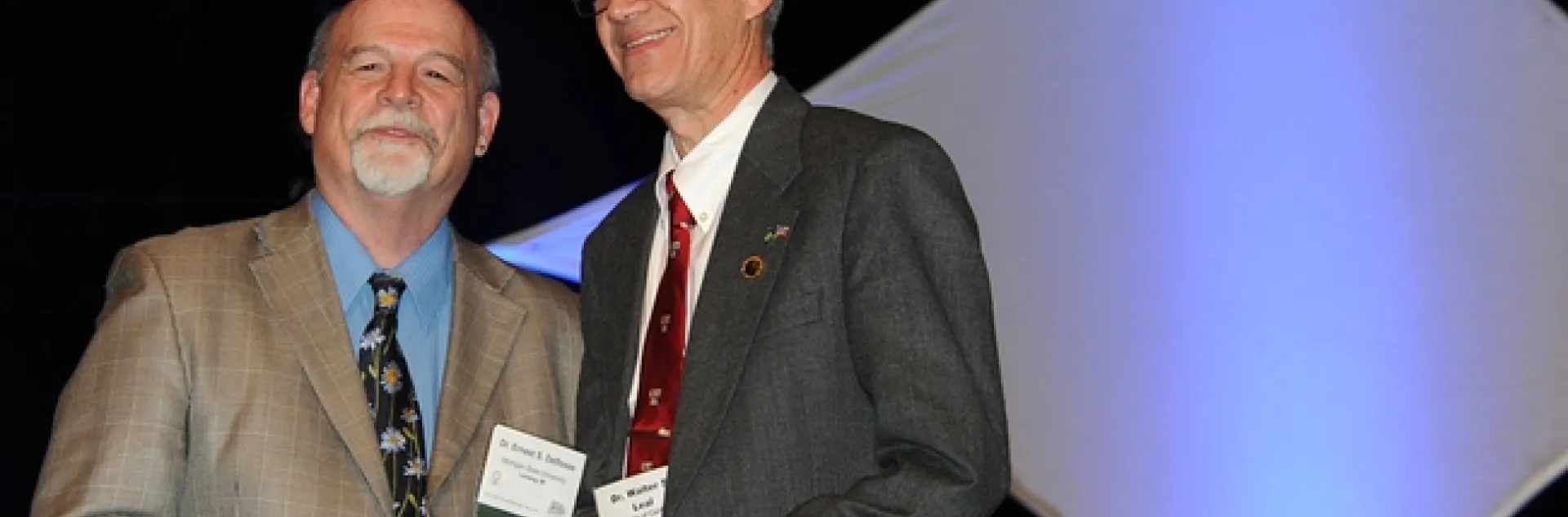 UC Davis pofessor Walter Leal (right) receives the Nan-Yao Su Award from ESA President Ernest Delfosse. (Photo by Kathy Keatley Garvey
