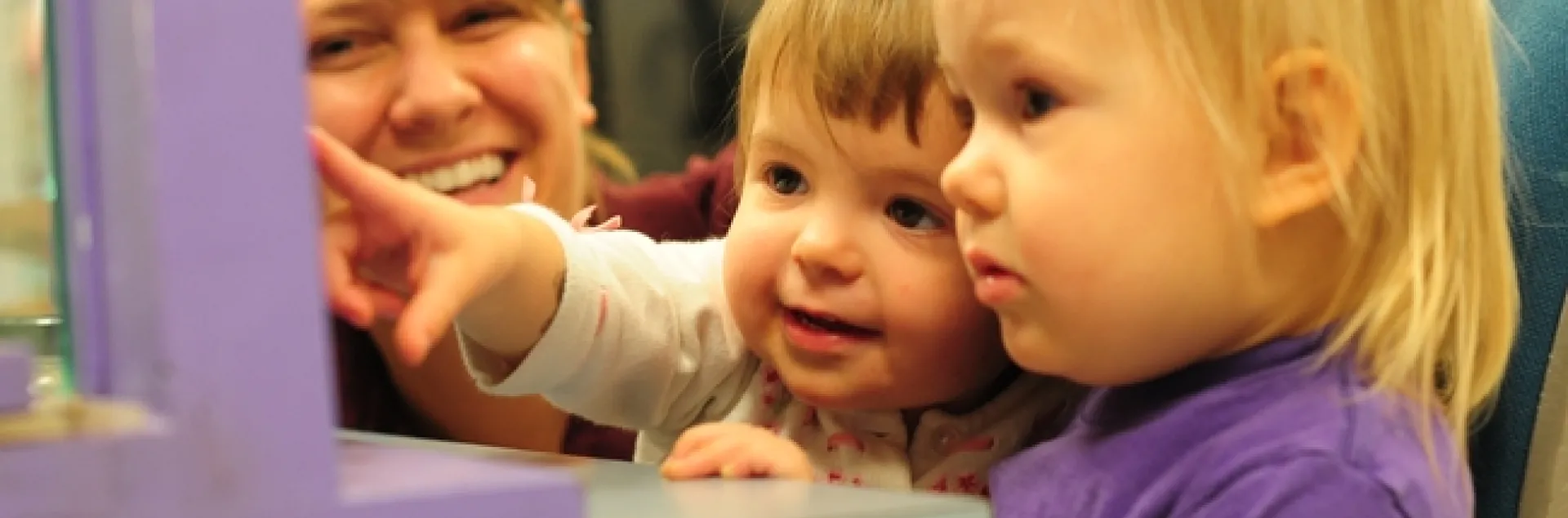 Leia Matern (far left) shows Vivienne Statham (center) and Tilly Matern the honey bee observation hive. (Photo by Kathy Keatley Garvey)