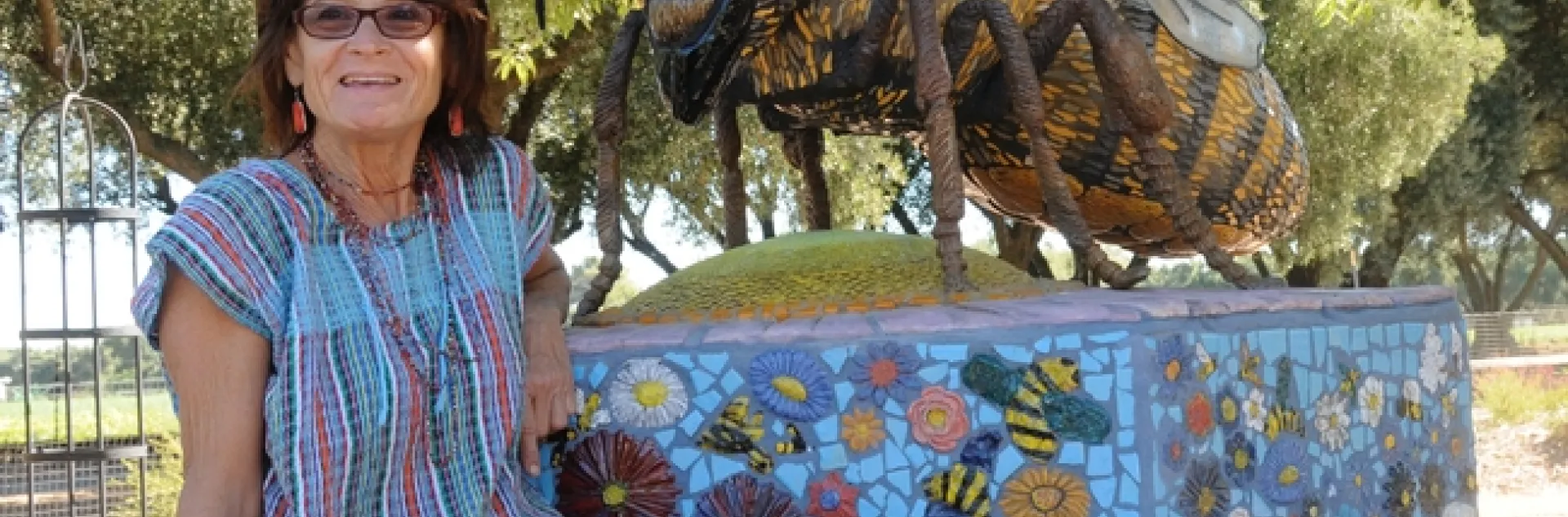 Donna Billick with her ceramic mosaic sculpture of a honey bee in the Haagen-Dazs Honey Bee Haven. (Photo by Kathy Keatley Garvey)