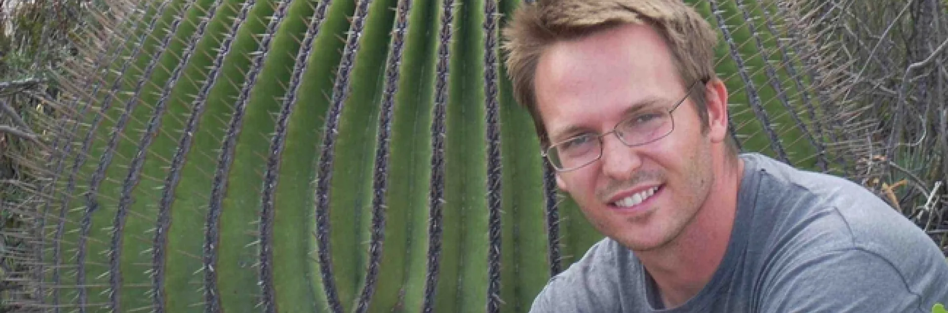 Alex Van Dam, photographed next to a giant cactus.