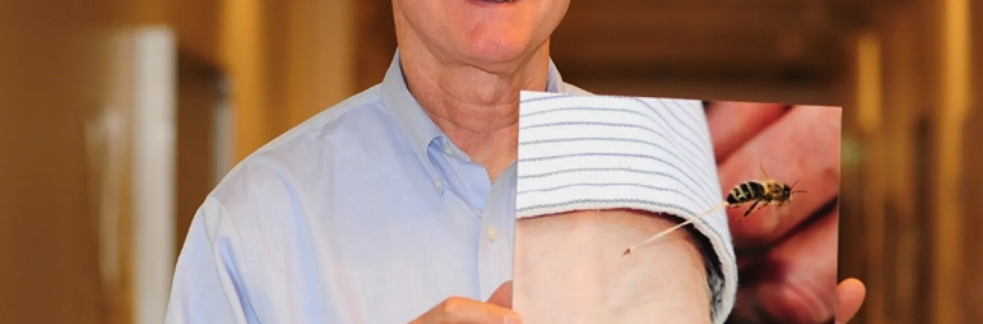 Eric Mussen and the famous bee sting photo showing a bee stinging his wrist. This mounted photo will be auctioned off at the California State Beekeepers' Association conference. (Photo by Kathy Keatley Garvey)