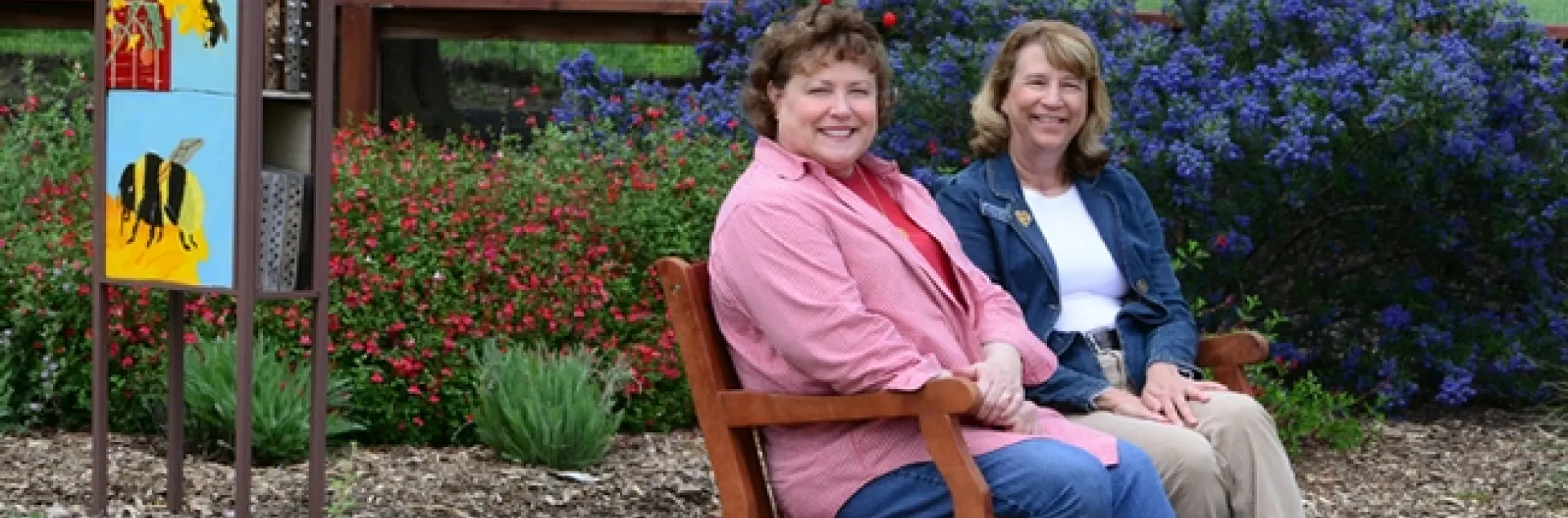 Debra Jamison (left), state regent, and Gayle Mooney, state treasurer, share a bench that the California State Society of the Daughters of the American Revolution purchased for the UC Davis bee garden.