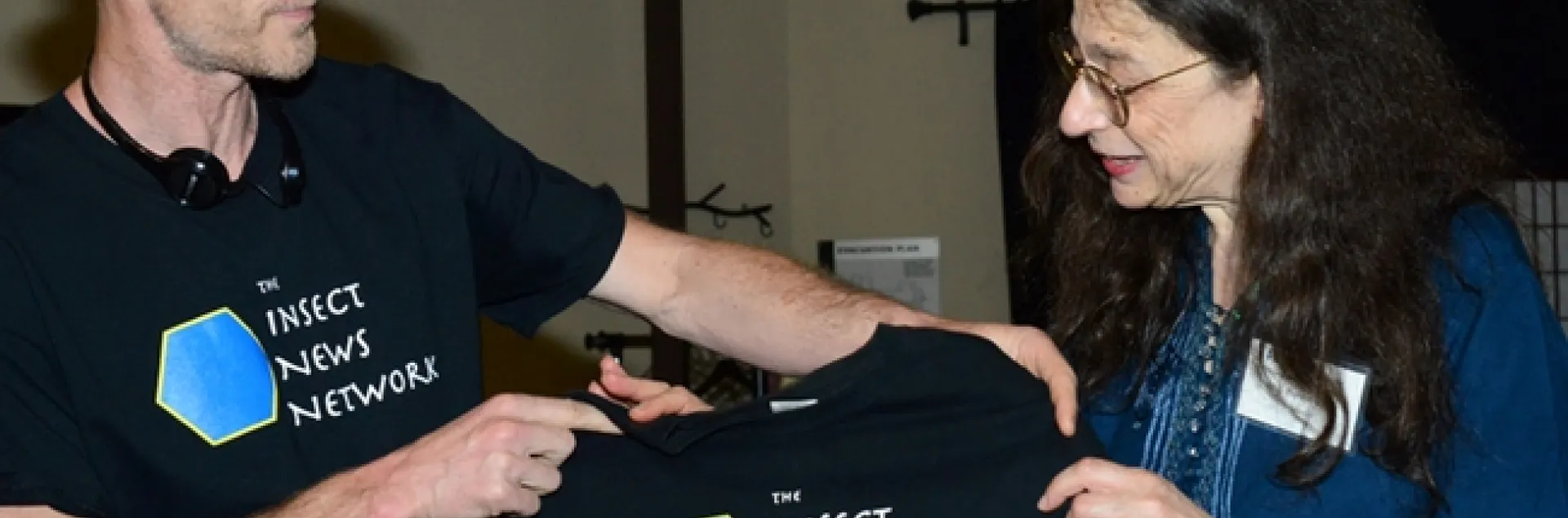 Emmet Brady, shown here with May Berenbaum, talks about the meaning of the Insect News Network t-shirt. (Photo by Kathy Keatley Garvey)