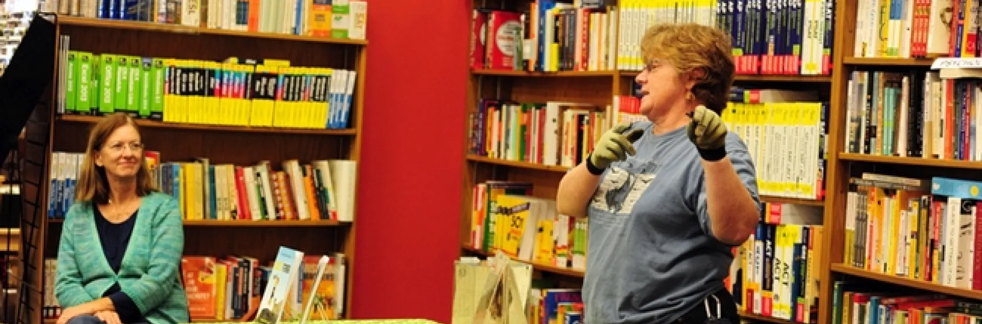 Rachael Long (left) and Corky Quirk talk about bats at an educational program at the Avid Reader, Davis. Quirk is holding a bat that's feeding on a mealworm. (Photo by Kathy Keatley Garvey)