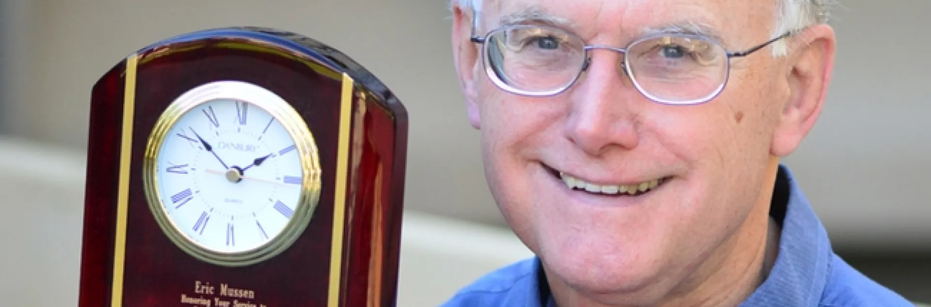 Extension apiculturist (emeritus) Eric Mussen with his engraved clock from the Almond Board of California. (Photo by Kathy Keatley Garvey)