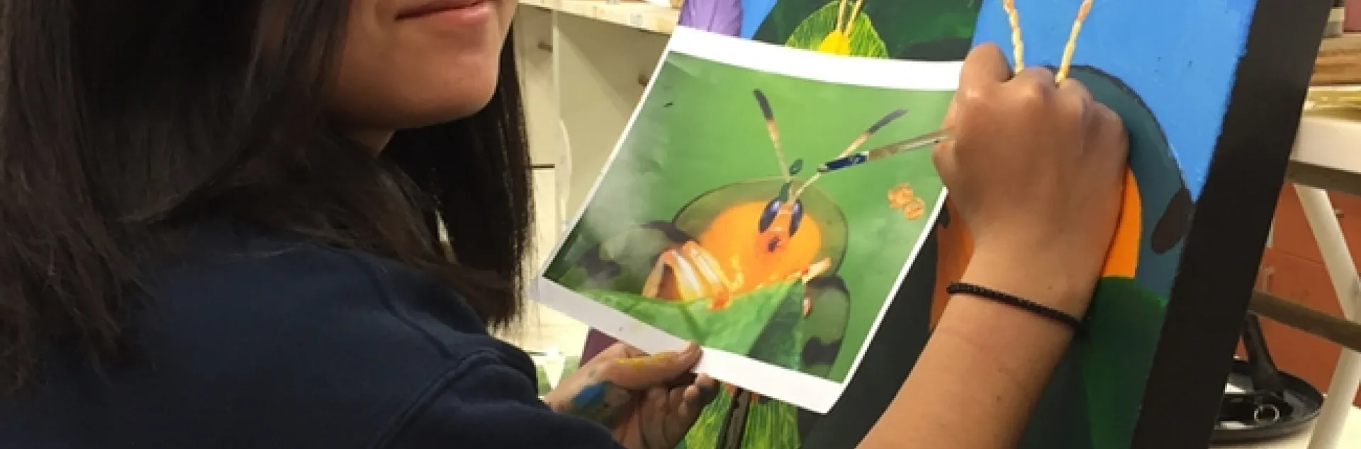 UC Davis student Kelly Aoyama works on a painting that will be displayed June 3 at a public art exhibit in Davis. (Photo by Diane Ullman)