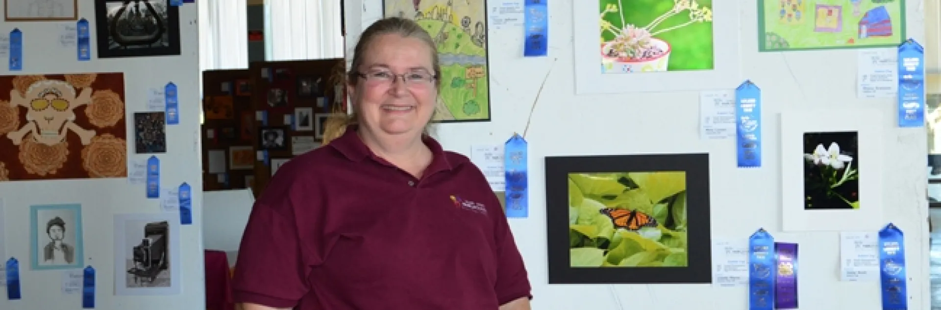 McCormack Hall assistant superintendent Sharon Payne of Vallejo, a past president of the Solano County 4-H Leaders' Council, stands next to youth photography featuring insects. (Photo by Kathy Keatley Garvey)