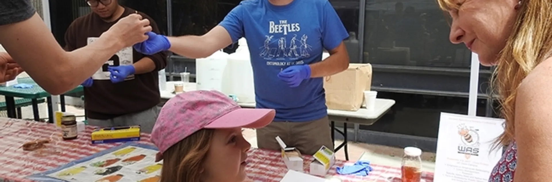 Graduate student Jackson Audley offers a sample at the Honey Tasting booth at Briggs Hall during the 2017 UC Davis Picnic Day. (Photo by Kathy Keatley Garvey)
