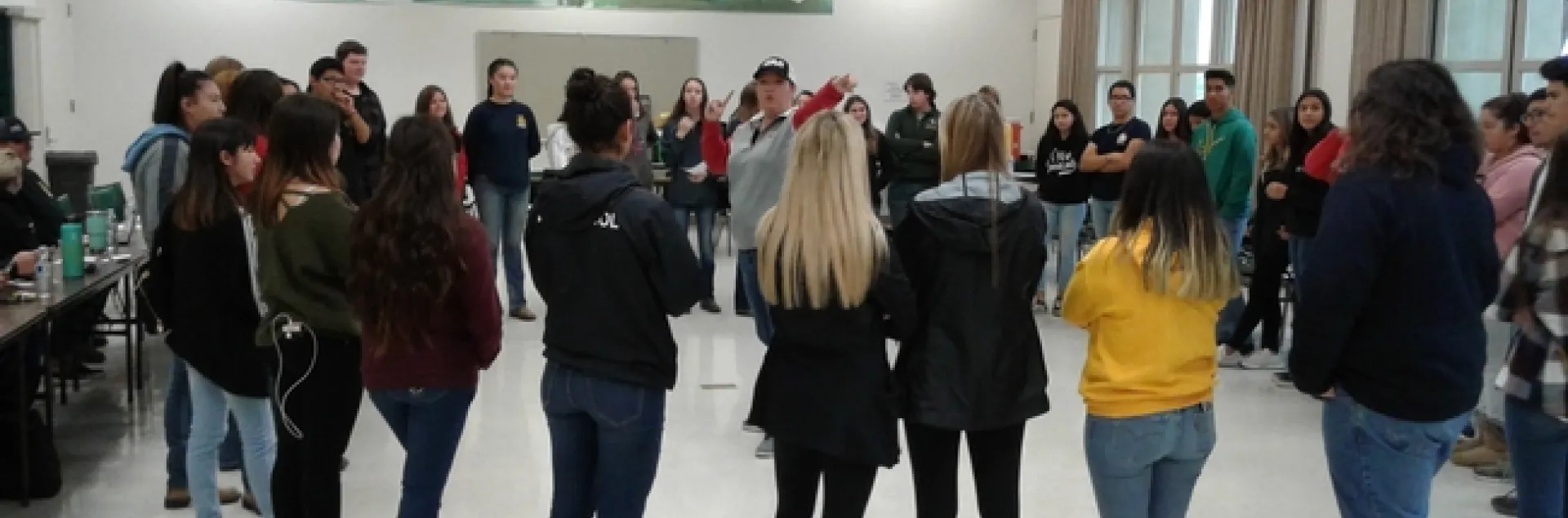 The students circle in a team-building exercise.