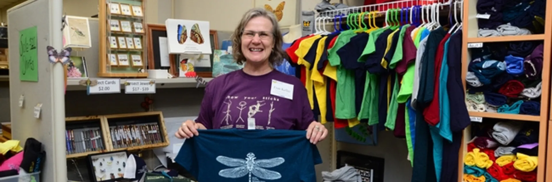 Bohart associate Fran Keller, an assistant professor at Folsom Lake College and a UC Davis alumnus (she received her doctorate in entomology studying with Lynn Kimsey) holds some of the new dragonfly t-shirts available at the Bohart Museum. (Photo by Kathy Keatley Garvey)
