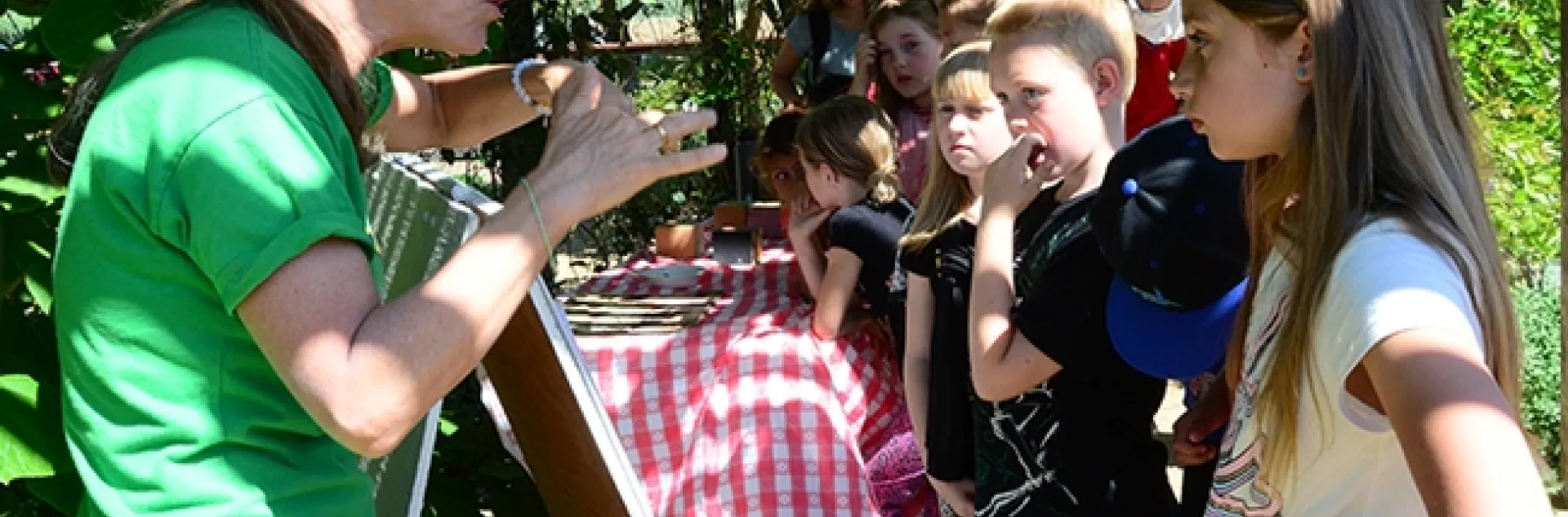 Wendy Mather (left) program manager of the California Master Beekeeper Program explains the life cycle of bees to a group of third graders from Amador County. (Photo by Kathy Keatley Garvey)