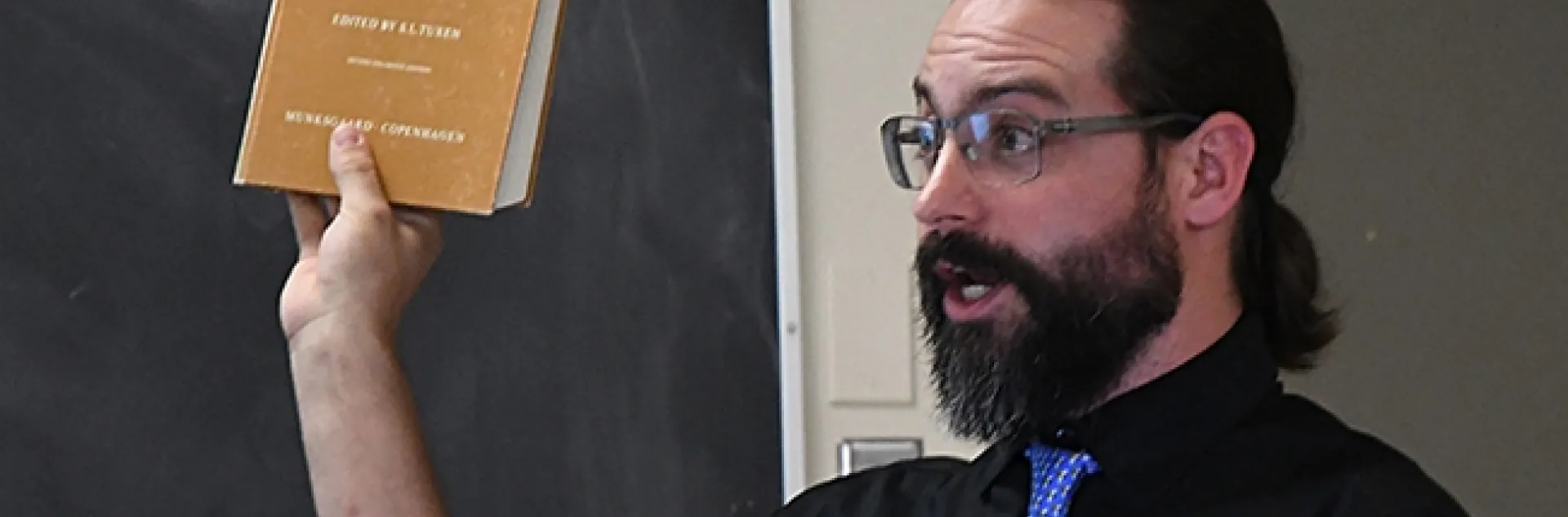 Ant specialist Brendon Boudinot recommends one of his dog-eared textbooks. (Photo by Kathy Keatley Garvey)