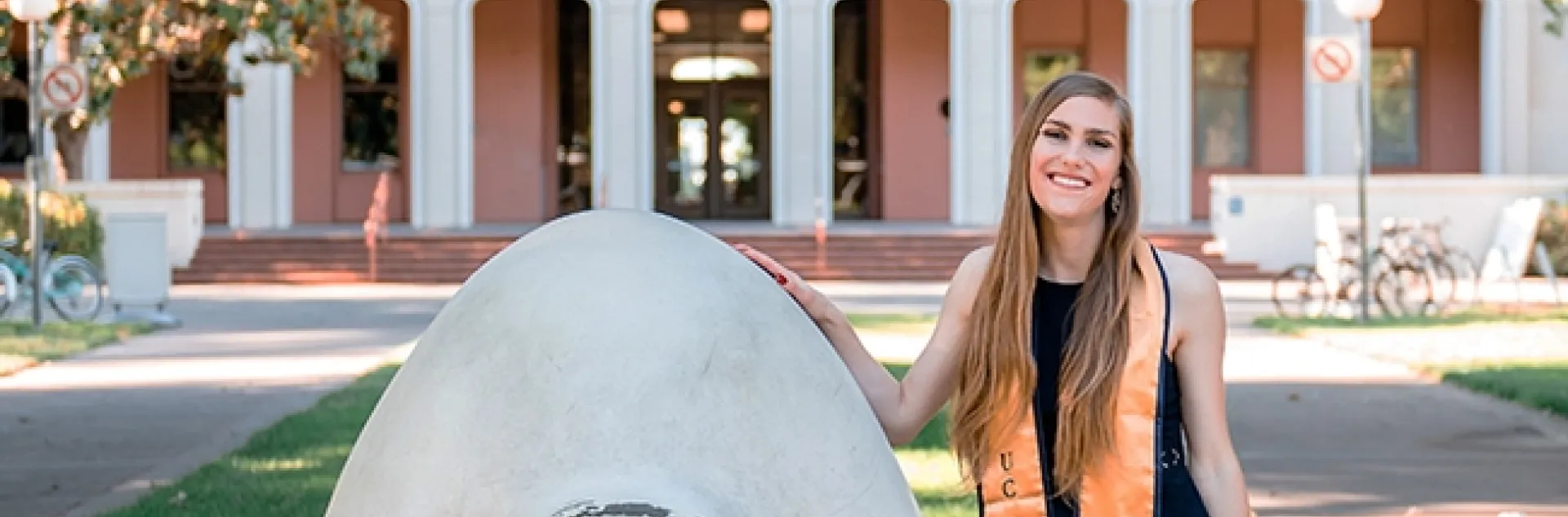 Jessica Macaluso stands next to Robert Arneson's egghead sculpture at Mrak Hall, UC Davis. She is scheduled to receive her bachelor's degree in the fall of 2020 in psychology with a biological emphasis.