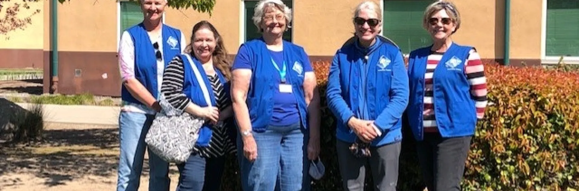 5 members of the committee standing in front of the garden space.