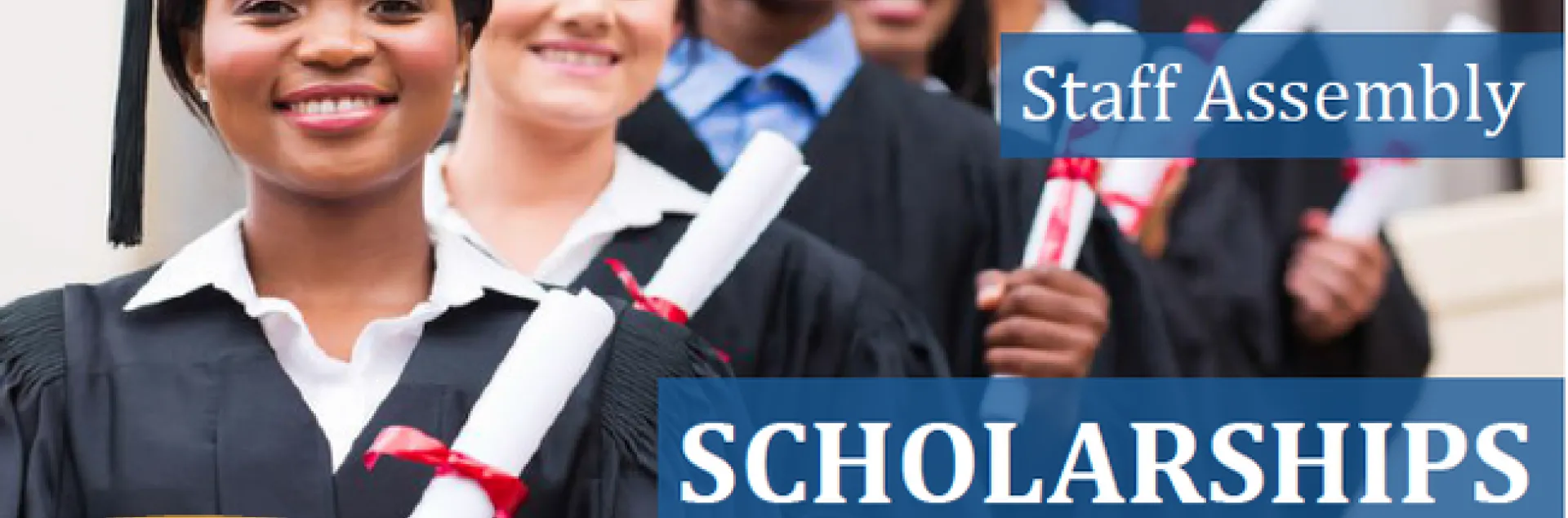 A diverse group of graduates wearing black caps and gowns and each holding a rolled up paper tied with a red ribbon.