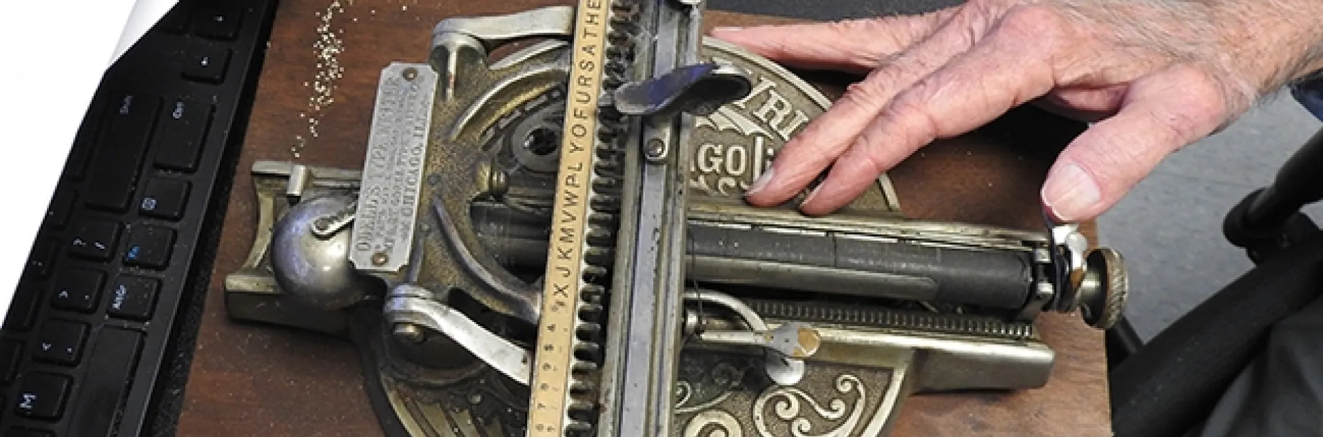 A hand of UC Davis distinguished professor Bruce Hammock rests on the Odell "type writer." (Photo by Kathy Keatley Garvey)