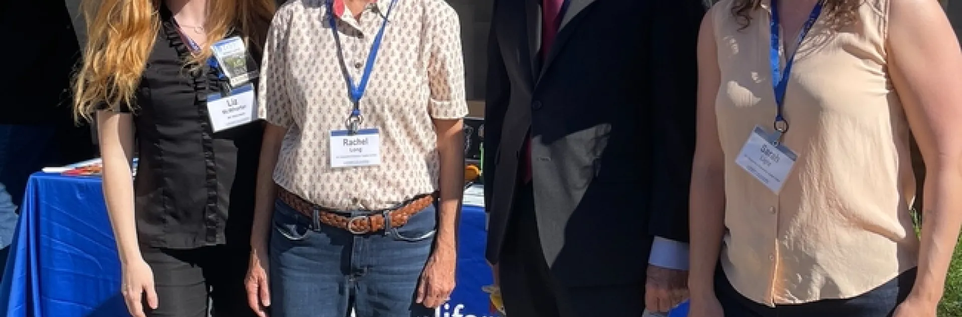 The four are standing in front of the Master Gardener booth under a banner that reads: University of California Agriculture and Natural Resources. Practical. Connected. Trusted.