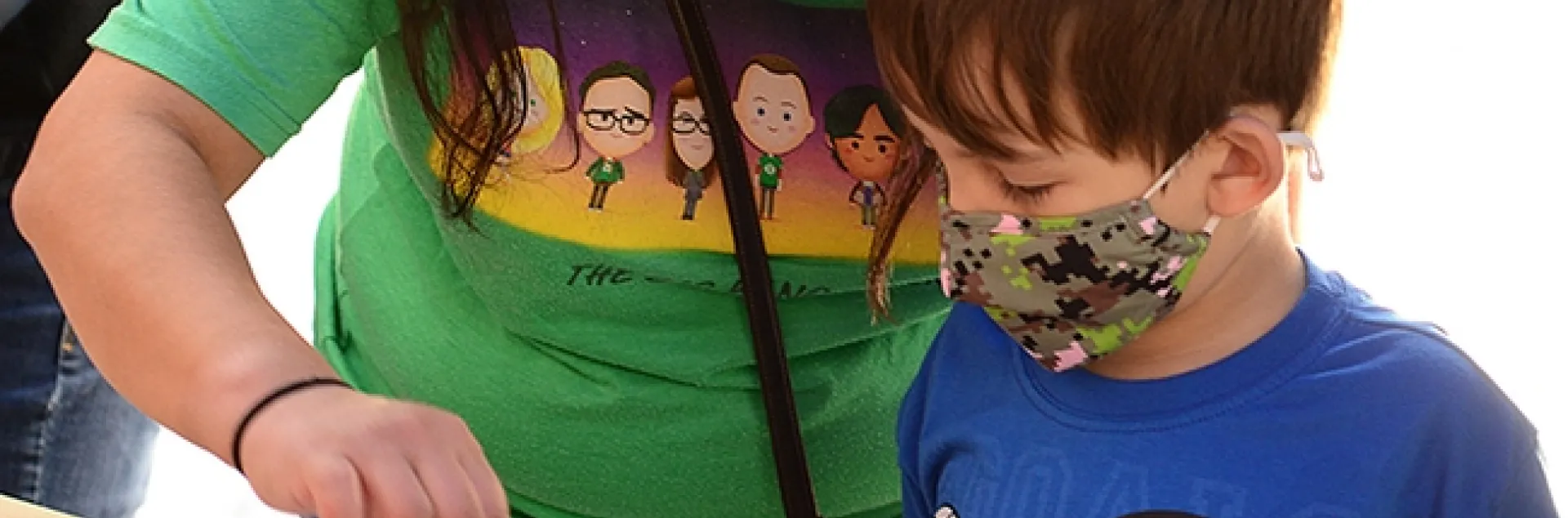 UC Davis alumnus Angie Velazquez of Los Angeles assists her son, Hudson Carr, 4, in his first Maggot Art project. (Photo by Kathy Keatley Garvey)