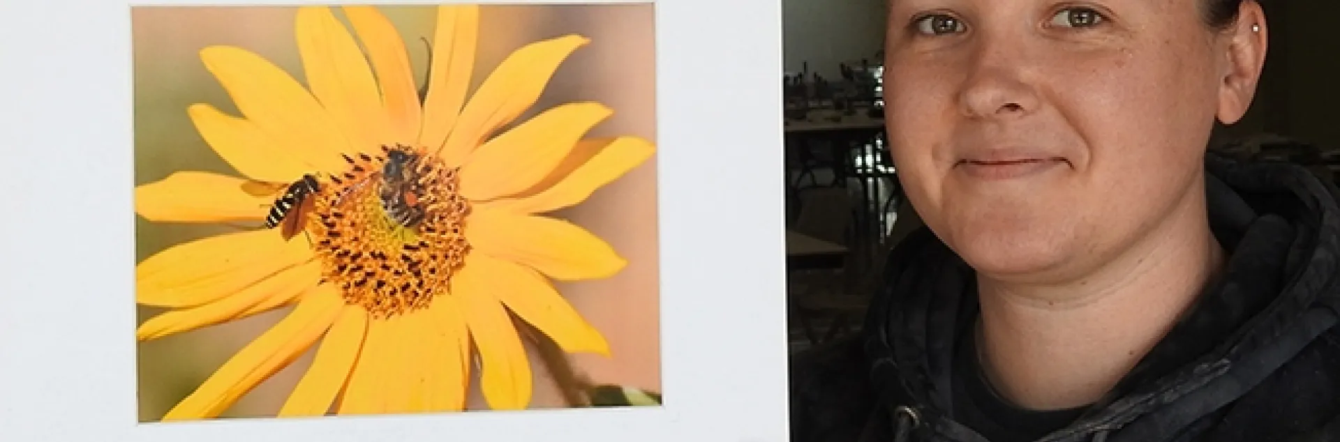 Marine biologist Leta Myers, who clerked at the Dixon May Fair judging, holds a photo by Vaca Valley 4-H'er Matthew Agbayani. It depicts a honey bee and a syrphid fly on a sunflower. (Photo by Kathy Keatley Garvey)
