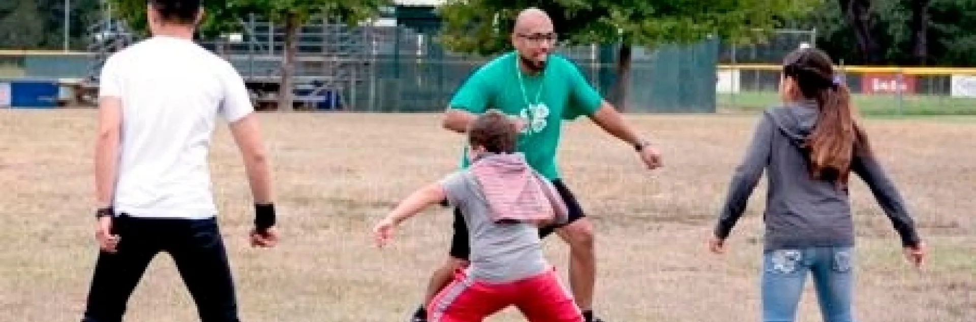Kids exercise outdoors with an instructor