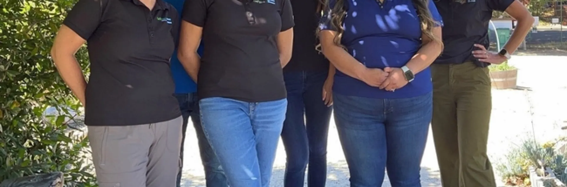 Miguel Diaz, Kelly Hong, Melissa LaFreniere, Abbi Marrs, Mishelle Petit, Rosa Vargas stand under a tree. Betsy Plascencia and Melissa Rorabough are missing from the picture.