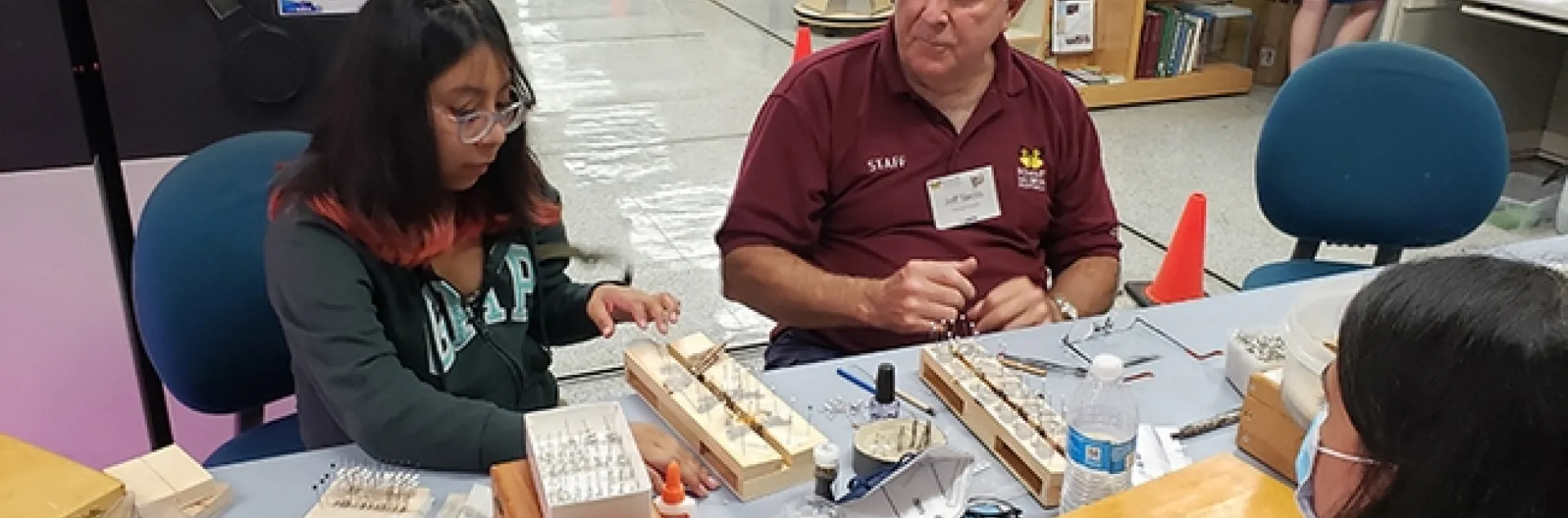Entomologist Jeff Smith, curator of the lepidoptera collection at the Bohart Museum of Entomology, shows a visitor how to spread the wings of a moth. (Photo by Tabatha Yang)