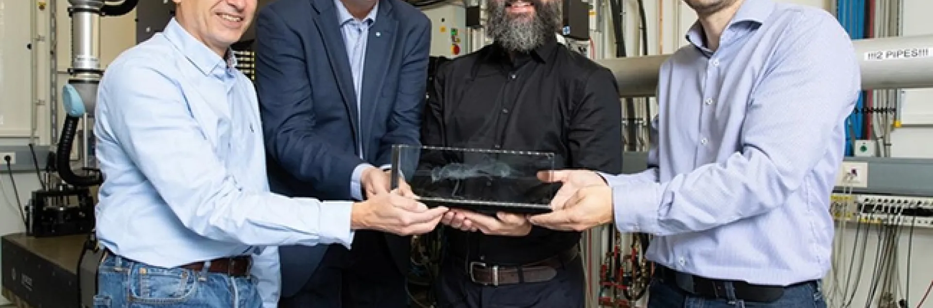From left: Martin Müller, director of the Institute for Materials Physics at Helmholtz-Zentrum Hereon, and Christian Schroer, leading scientist of DESY's X-ray source PETRA III, accept a model of the newly identified ant from lead author Brendon Boudinot of the Friedrich Schiller University Jena, and co-author Jörg Hammel, beamline scientist at the Hereon measurement station at PETRA III, where the research took place. (Photo courtesy of Marta Meyer, DESY)