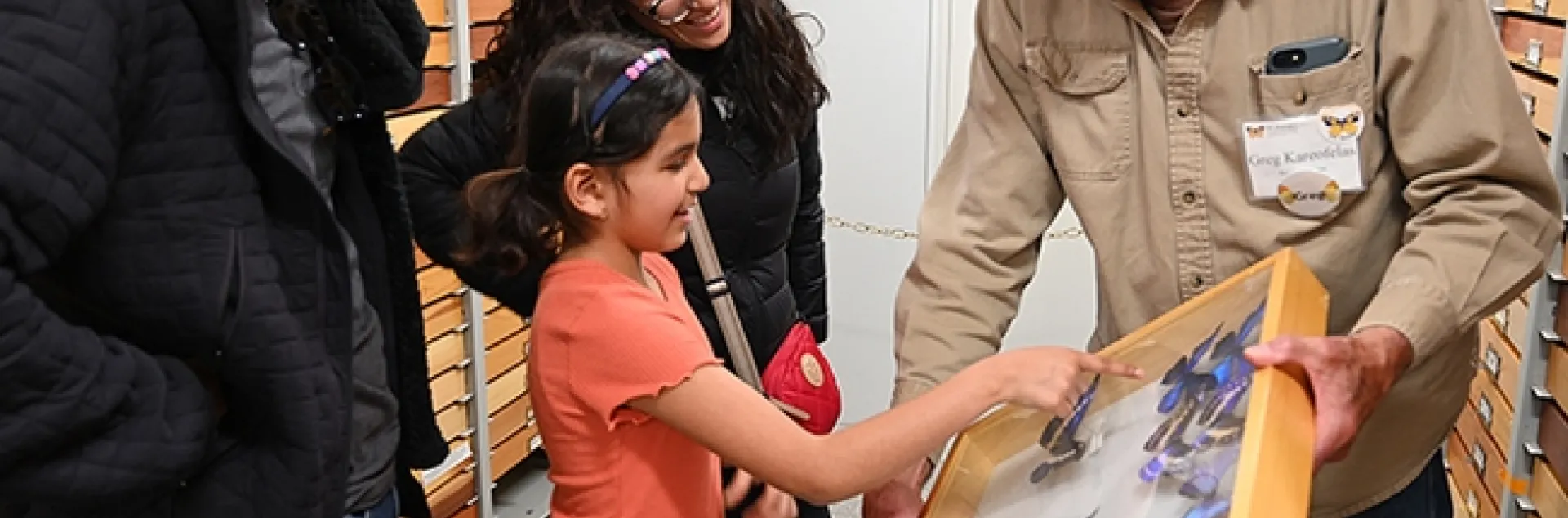 Martha Leija and Mario Preciado and their daughter Valentina, 8, a family from Mexico City, check over the morpho butterflies. At right is Bohart associate Greg Kareofelas. (Photo by Kathy Keatley Garvey)