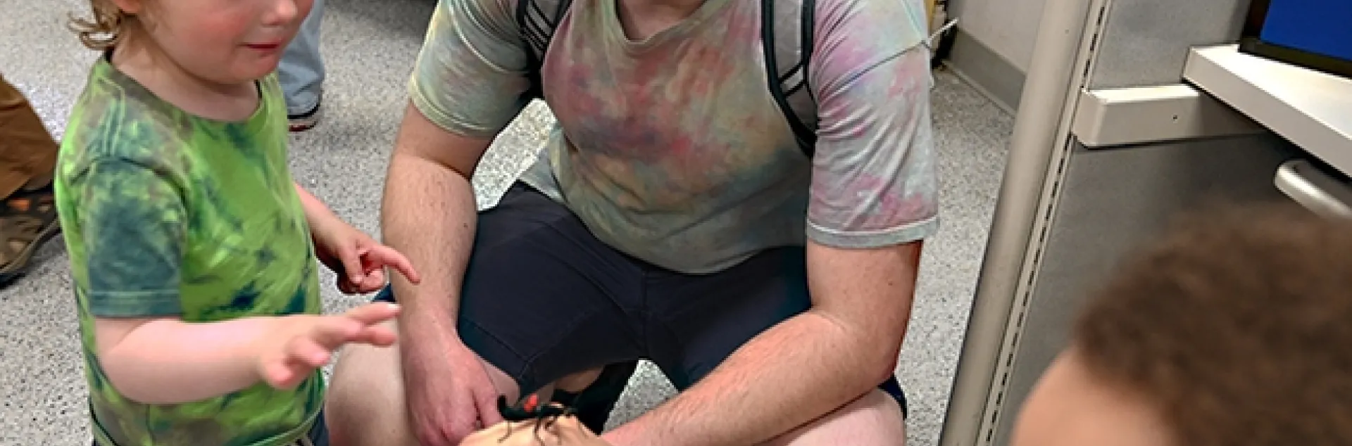 Milo Buterbaugh, 2, of Vacaville, accompanied by his father, Dylan Buterbaugh, gets acquainted with a walking stick held by Bohart associate Christofer Brothers, a UC Davis animal behavior doctoral candidate. (Photo by Kathy Keatley Garvey)