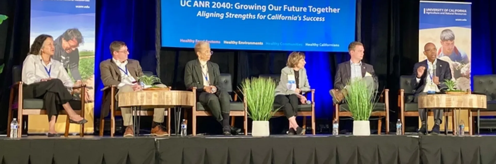 Six people sit on stage under a banner that reads: “UC ANR 2040: Growing Our Future Together, Aligning Strengths for California's Success”