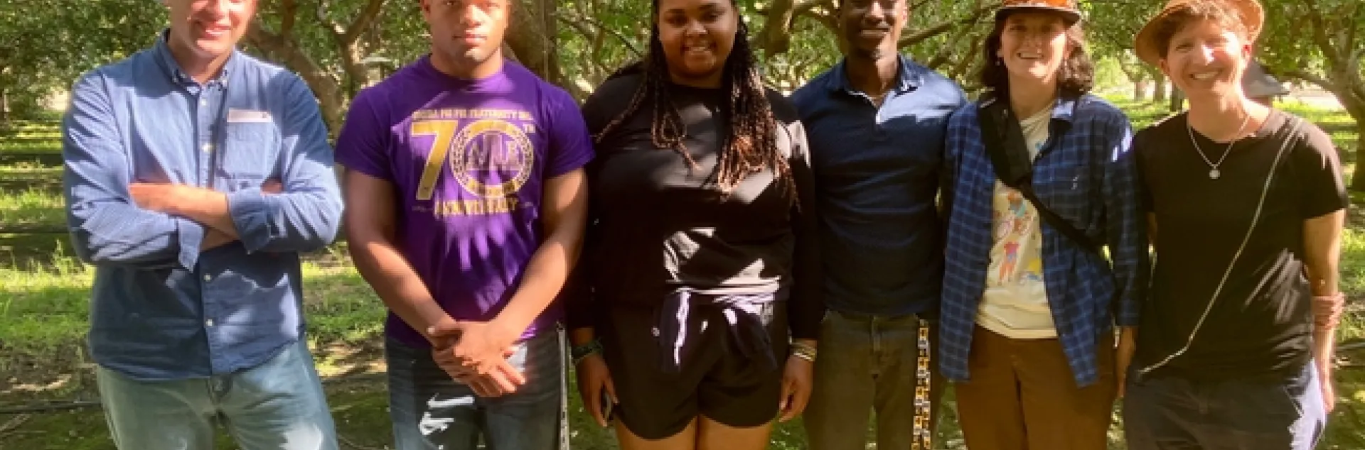 The group stands among trees