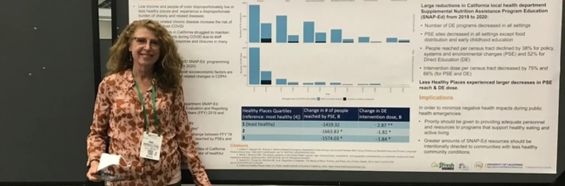 Gail Woodward-Lopez stands by a poster in Boston